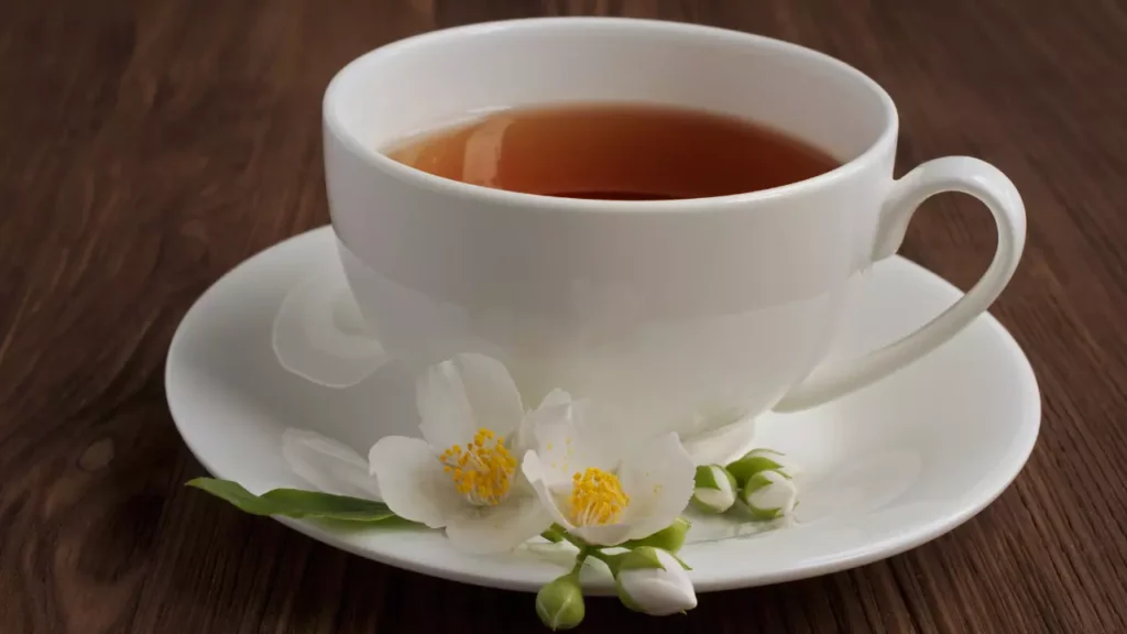 عبارات عن الشاي. الوصف: كوب شاي أبيض مع زهرة بيضاء عليه.